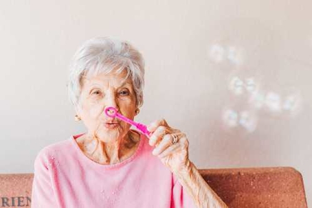 Elderly woman blowing bubbles