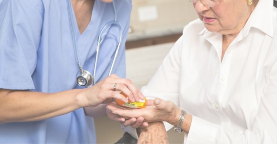doctor giving elder patient medication