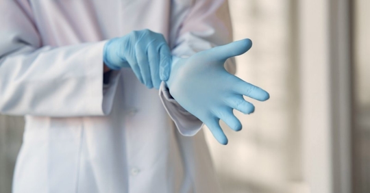 medical professional putting gloves on