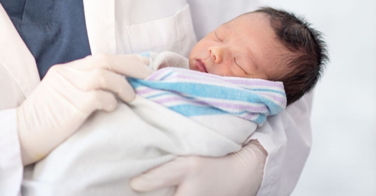Doctor holding a newborn baby.