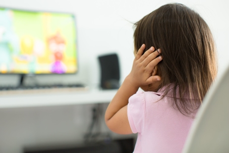 Little Girl Covering Ears at TV