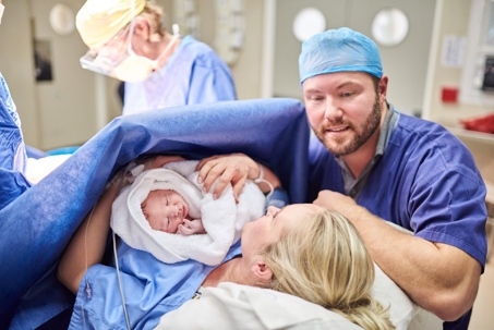 Mother and Father with Newborn in Delivery Room