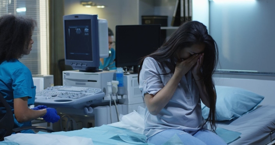 Pregnant woman crying in hospital