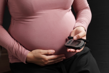 Pregnant woman checking her blood sugar