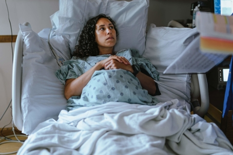 Pregnant woman listening to doctor in hospital bed