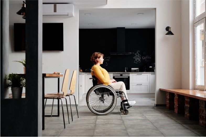 paralyzed woman in a wheelchair staring out the window